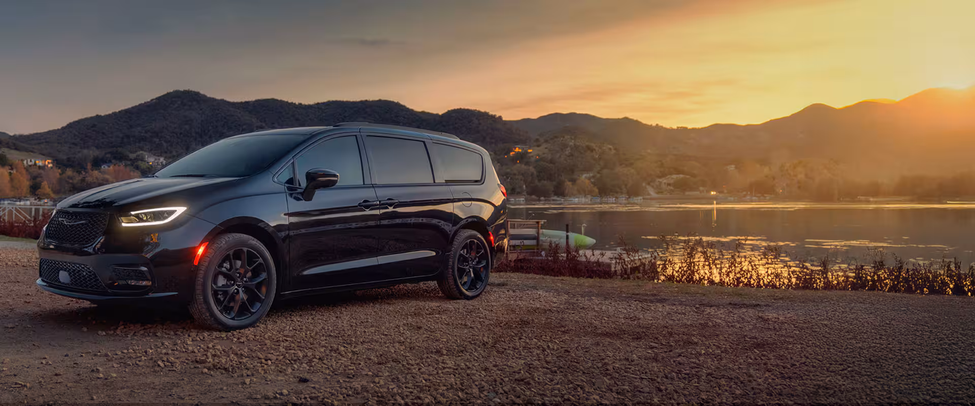 A black 2025 Chrysler 一分钟极速赛车开奖官方网站 Pacifica Limited parked by a lake at sunset.
